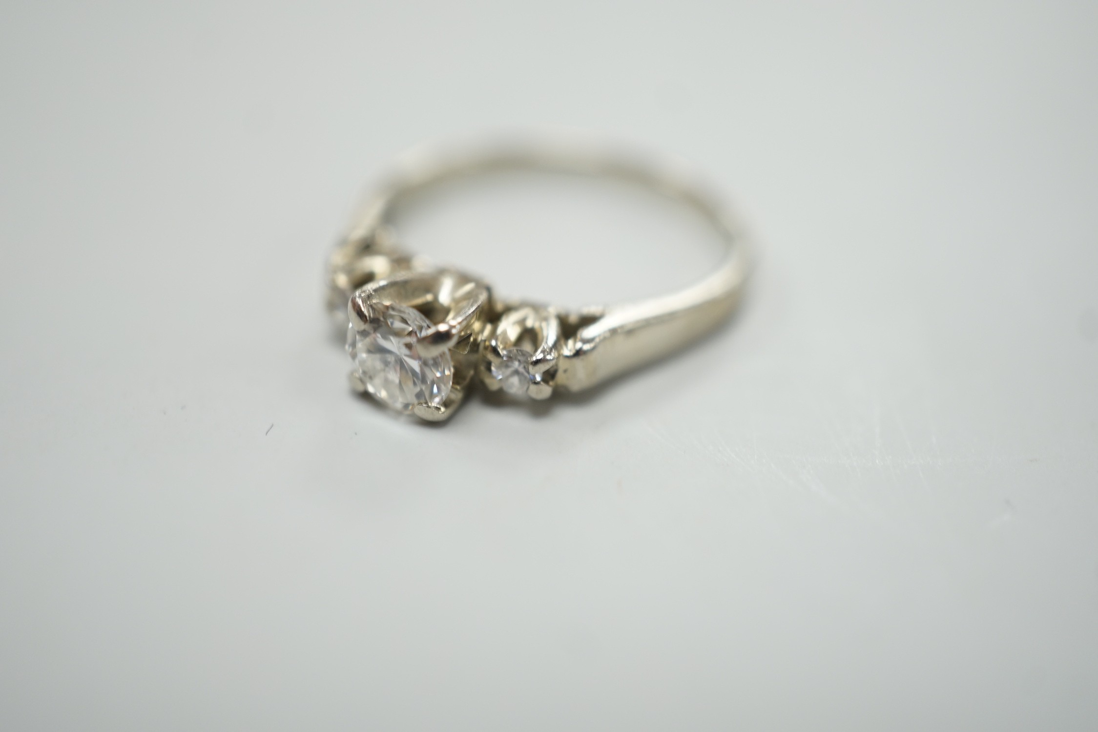 A Canadian Birks 18k white metal and single stone diamond ring, with diamond set shoulders, size H, gross weight 2.7 grams